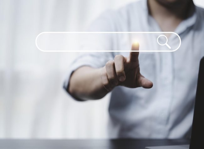 Hand touching with search icon for Search Engine Optimisation or SEO concept to find information by internet connection.